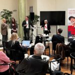 Tre kvinnor och en man pratar inför åhörare.