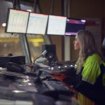 Kvinna arbetar i kontrollrum i industrimiljö i Dalarna.